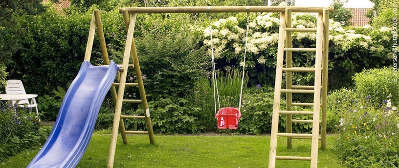 Spielgeräte: Schaukel und Rutsche für Kinder im Garten.
